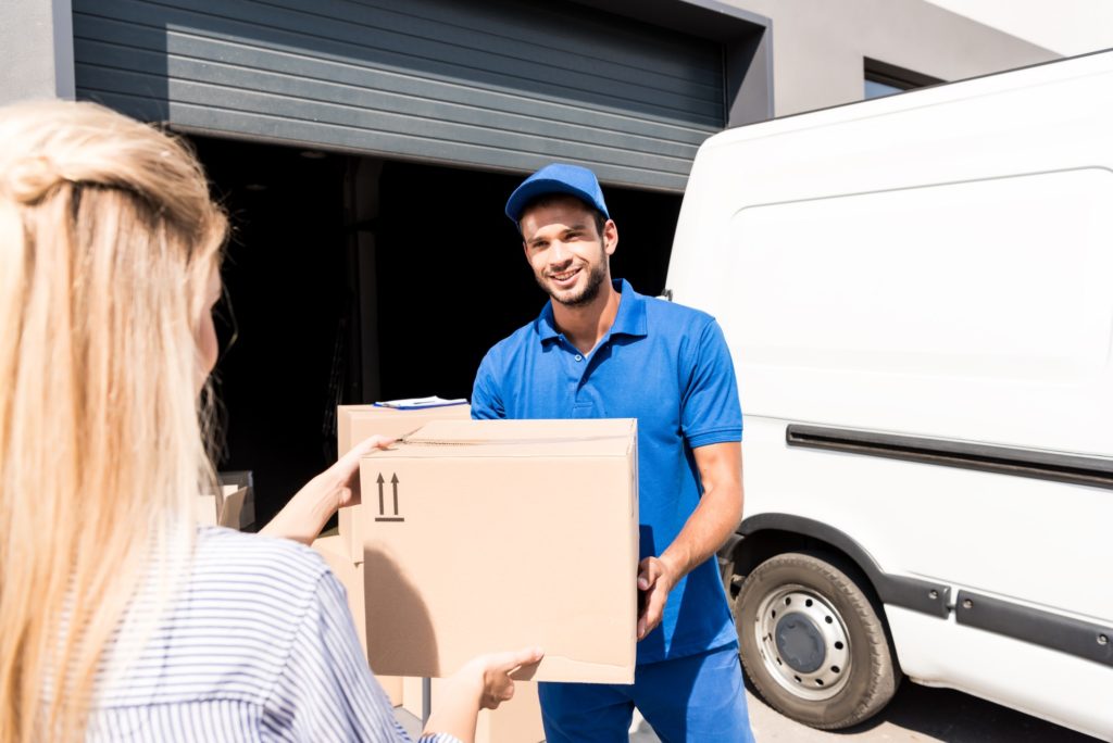 happy young courier giving package to woman