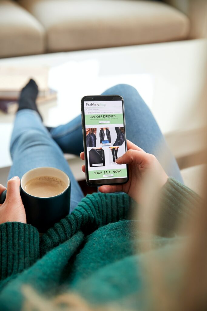 Close Up Of Woman Shopping For Clothes Online Using Mobile Phone App